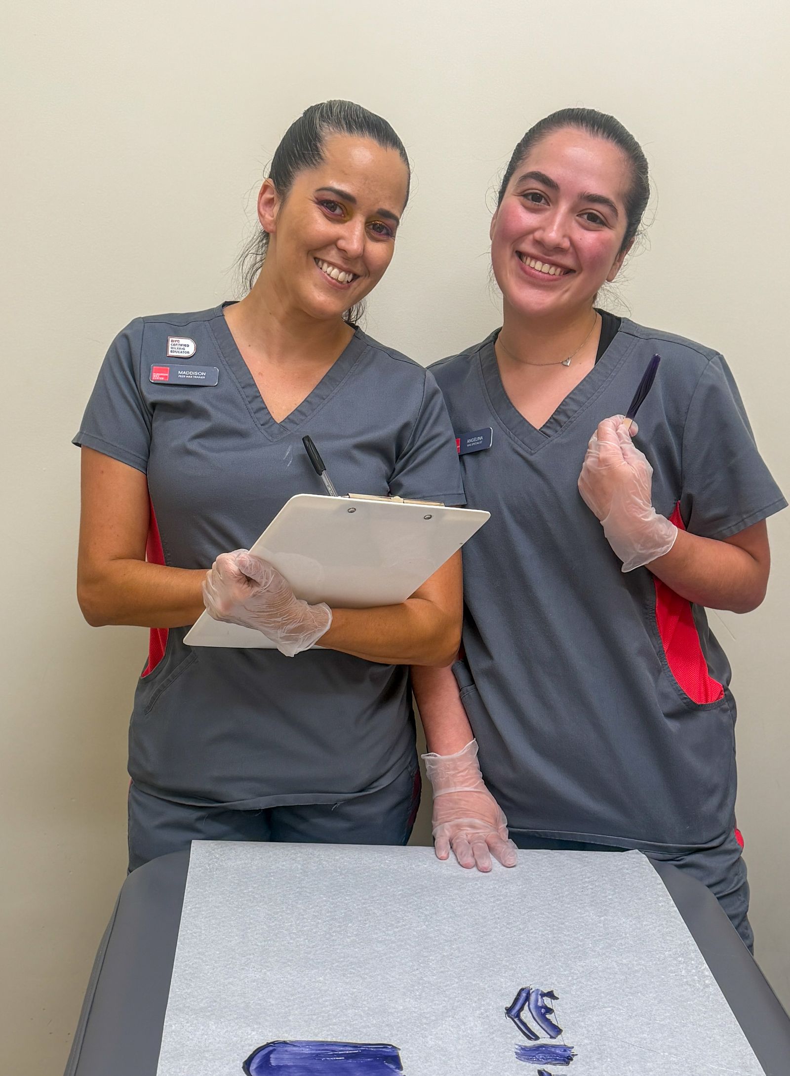 Maddison, a Peer Wax Trainer, with Angelina, a Wax Specialist she is training